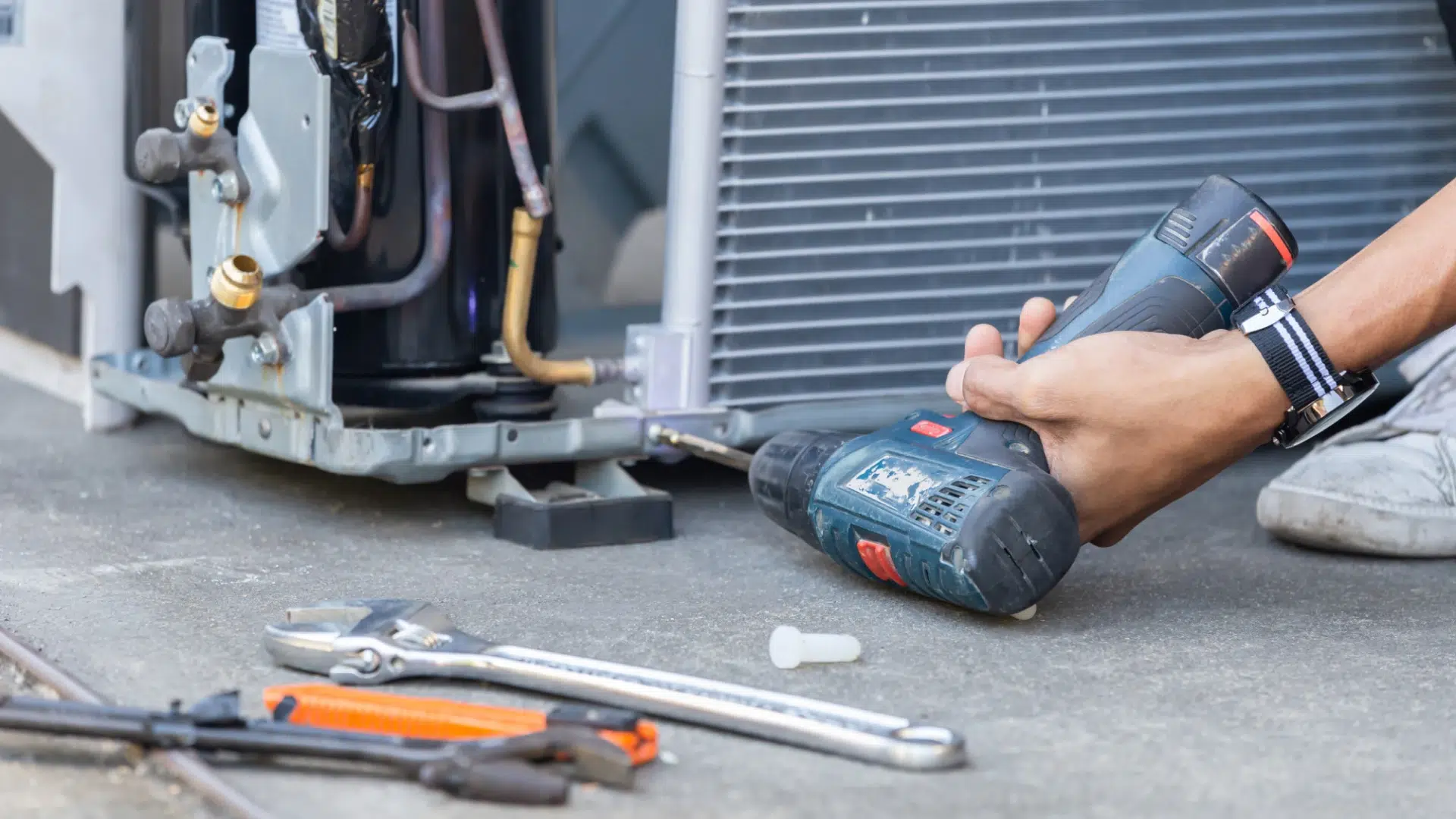 Person using drill near AC